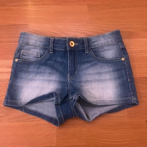 Blå jeansshorts från LAB Industries - Snygga blå jeansshorts från LAB Industries med klassisk femficksdesign, gylf med knapp och bälteshällor. Shortsen har en cool tvättad look och är tillverkade i mjukt denim. Perfekta för varma dagar och enkel att matcha med allt.