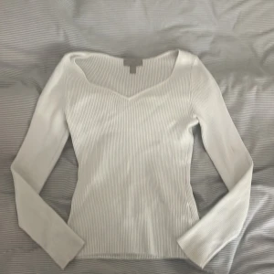 Vit ribbad långärmad topp H&M - Vit ribbad långärmad topp från H&M med snygg v-ringning. Figurnära passform och stretchigt material. Perfekt till jeans eller kjol. Enkel att styla och superbekväm. 💗 har en liten fläck på armen, men syns knappt