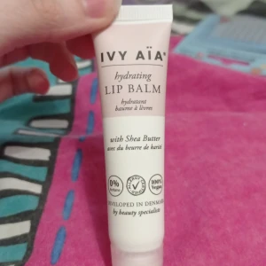 Ivy Aïa Hydrating Lip Balm - Återfuktande läppbalsam från Ivy Aïa med sheasmör. Kommer i en söt, ljusrosa och vit tub. 100% vegansk och parfymfri, utvecklad i Danmark. Perfekt för torra läppar och innehåller vårdande oljor och smör. Har använt 