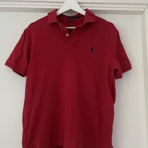 Röd pikétröja från Polo Ralph Lauren - En stilren röd pikétröja från Polo Ralph Lauren i mjuk pima-bomull.  Perfekt för en varm sommardag. Skick 8/10. Kan gå ner i pris vid snabbafärr.