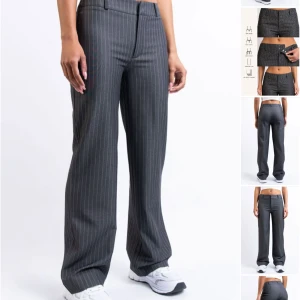 Grå randiga kostymbyxor wide fit - Snygga grå kostymbyxor med tunna vita ränder i ett klassiskt pinstripe-mönster. Byxorna har hög midja, vida ben och bälteshällor. Perfekta för en stilren och trendig look. Passar till sneakers eller boots. Längd: Regular. Passar mig som är 168. Stora i storlekarna så 32 passar mig som har 34-36 i storlek. Nypris: ca 700kr