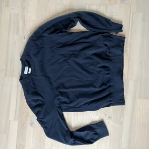 Marinblå sweatshirt från These Glory Days - En stilren marinblå sweatshirt från These Glory Days i mjuk bomull. Tröjan har rund halsringning, långa ärmar och ribbade muddar vid ärmslut och nederkant. Perfekt för en clean och avslappnad look.