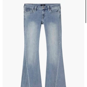 True Religion ljusblå bootcut jeans - Säljer ett par ikoniska ljusblå bootcut jeans från True Religion med snygga detaljerade bakfickor och silverfärgade knappar. Jeansen har låg midja och klassisk femficksdesign. Perfekta för dig som vill ha en cool och avslappnad look. Passar dig som är lite kortare. Jag är 161 och dom passar perfekt, lite långa, så om man är längre än 161 så funkar dom också.