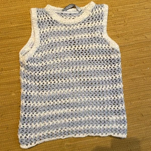 Randig stickad linnetopp Sportmax / gren av Max Mara - Säljer en superfin stickad linnetopp från Sportmax Code i storlek S. Toppen är ärmlös och har ett öppet, virkat mönster i ljusblått och vitt med randig effekt. Perfekt för varma dagar när du vill ha en chill och luftig vibe.