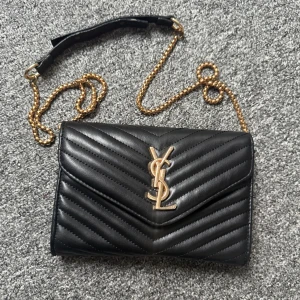 Ysl väska - En ysl väska som ej är använd. Fick den i present men kommer ej till användning. I bra skick. Kedjan är ganska lång och går ej att förkortas tyvärr. Kommer ner till höften på mig som är 1,65. Säljer för 400kr men kan gå ner i pris vid snabb affär. 