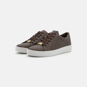 Bruna sneakers från Michael Kors - Snygga bruna sneakers från Michael Kors. Skorna har bruna snören och guldfärgade detaljer framtill som ger en lyxig touch. Perfekta för dig som gillar stilrena och trendiga skor. Köpte för 1400 och skorna är helt oanvända