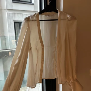 Blus krämvit nakd  - Satinblus, nyskick och intagen midja med luftiga armar