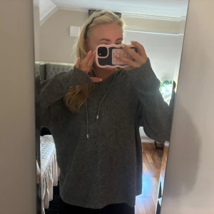 Mörkgrå stickad hoodie med snörning - Säljer denna stickade hoodie som jag köpt i Spanien på en marknad! Säljer pga att den inte riktigt kommit till användning! 