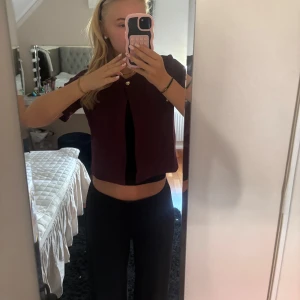 Vinröd croppad bolerotopp med knapp - Säljer denna vinröda blusen/ koftan! Den ör köpt ifrån Gina förra året, men kom inte så mycket till användning!