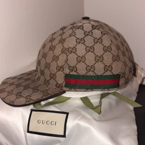 Gucci keps med GG-mönster och läderdetalj - En stilren Gucci gg canvas baseball keps, passar både lite finare tillfällen men även vanlig vardag. Nypris ligger på 5600 mitt pris 2700. Den är såklart äkta och kvitto finns med box och allt som följer med🙌🏼🙌🏼