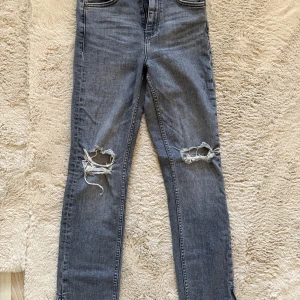 Grå ripped jeans från Zara, strl 36 - Snygga grå jeans från Zara i storlek 36 med slitningar.