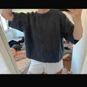 Mörkgrå loose stickad tröja - Mysig och oversized stickad tröja i mörkgrå färg. Tröjan har en rund halsringning och breda, lite kortare ärmar. Materialet är fluffigt och känns riktigt skönt mot huden, perfekt för chill dagar. Passformen är loose och ger en avslappnad vibe.