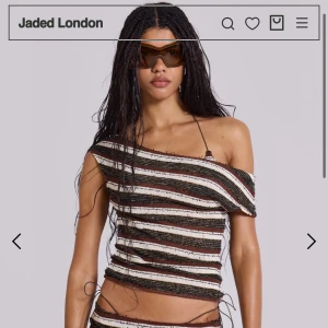  asymmetrisk topp från Jaded London - Säljer en stickad, asymmetrisk topp från Jaded London med bruna, svarta och vita ränder. Passar storlek XS. Oanvänd! 