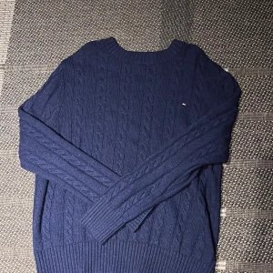 Kabelstickad tommy hilfiger tröja - Marinblå kabelstickad tröja av Tommy Hilfiger i storlek S, perfekt till kallare dagar