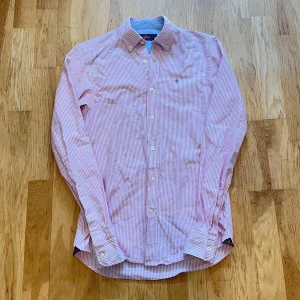 Rosa skjorta-Morris - Säljer en helt ny skjorta från Morris i storlek XS med rosa/vita ränder med morris-loggan på bröstet. Tillverkad i 100% bomull! Skicka ett DM vid frågor!!