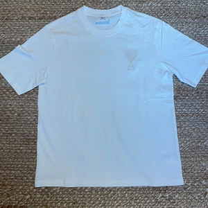 Vit t-shirt från Ami Paris - Vit t-shirt från Ami Alexandre Mattiussi med broderad logga. Aldrig använd. Säljer pga att den var för stor. Storlek medium men passar även large då den är lite oversized. Priset går att diskuteras. 