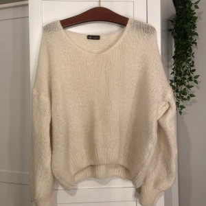Krämvit stickad tröja Chelsea Girls - Supermjuk och fluffig krämvit stickad tröja från Chelsea Girls. Tröjan har en avslappnad passform och är perfekt för lager på lager outfit!