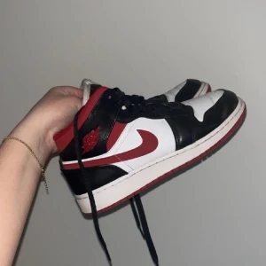 Nike Air Jordan 1 Mid svart/röd/vit - Säljer mina Jordans 1 ”gym red” mid. Inköpta för 3199 kr! De är Nike Air Jordans med svart, vit och röd färg. Skorna har högt skaft, röd sula och röda skosnören. Pris kan diskuteras 