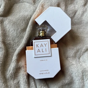 Kayali Vanilla | 28 Eau de Parfum 100ml - Kayali Vanilla | 28 är en lyxig parfym i en elegant, oktagonformad glasflaska med guldiga detaljer och kristallin kork. Doften är varm och söt med tydlig vaniljton. Kommer i en stilren vit och guldig förpackning. Flaskan rymmer 100 ml Eau de Parfum.