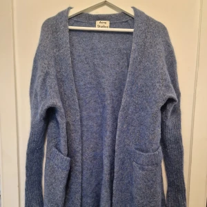 Blå mohair kofta från Acne Studios - Mysig blå kofta från Acne Studios i raya mohair. Supermjuk och sticker inte alls. Perfekt för lager-på-lager och chill vibes under kyliga dagar. Utsåld och nypris strax över 5000 kr. Använd under 5 gånger så nästan ny. Deras XXS är likvärdig S-M och till och med liten L.