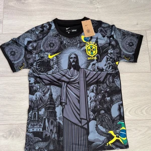 Nike Brazil fotbollströja  - Unik Brasilien fotbollströja från Nike med Dri-Fit material. Tröjan har ett detaljerat grafiskt tryck med Kristusstatyn, brasilianska symboler och CBF-emblem i gult. Svart bas med grå och gula inslag, korta ärmar och rund hals. Perfekt för dig som vill sticka ut på planen. 