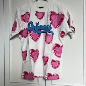 Vit t-shirt med rosa hjärtan från Doğanci - Limited edition oversize T-shirt från Doğanci. Använd en gång!