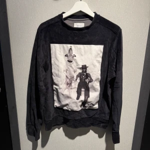Svart sweatshirt Limitato x Terry O'Neill - Cool svart sweatshirt från Limitato med ett stort svartvitt fotoprint framtill av Terry O'Neill. Tröjan har rund hals och långa ärmar
