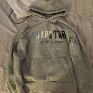 Trapstar hoodie  - Säljer en grå hoodie från Trapstar. Den är i bra skick och inte använd så många gånger. Den har bara en liten fläck på fickan. Skriv privat om du vill ha mer bilder💕