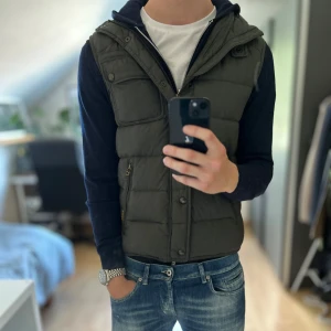 Ralph Lauren Dunväst -  Bra skick, lite sliten men absolut inget som märks . Storlek S passar dig som är mellan 178-188cm. Olivgrön färg. Nypris ca 3000kr. Modellen är 185 cm, 79 kg. Passar bra nu till sen sommar/höst. Skriv för mer information!🤝