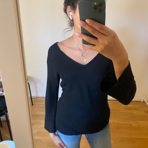 Svart v-ringad tröja - Snygg svart v-ringad tröja med Trekvartsärmad. Perfekt för en stilren look och passar bra till jeans eller kjol. Enkel och elegant design
