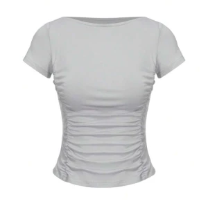 Vit kortärmad topp - Säljer en stilren vit topp med korta ärmar och rynkade detaljer på sidorna. Perfekt för en enkel och chic look.