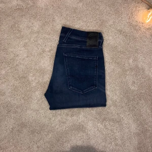 Replay Anbass - Replay Anbass jeans – Mörkblå, strl 21/36 men sitter som 30/33, grym passform!”  Säljer ett par mörkblå Replay Anbass jeans i storlek 31W/36L men sitter som 31/33. Klassisk slim fit med perfekt stretch och bekväm passform. Varsamt använda, i mycket fint skick helt utan defekter. Kvalitetsjeans som funkar både till vardags och fest! Nypris: 1 600 kr Mitt pris: 599 kr