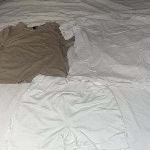 Beige och vit t-shirt från Shein och Gina Tricot - Två t-shirts i olika färger: en beige från Shein i storlek L och en vit från Gina Tricot i storlek XL. Perfekta för en avslappnad stil. Tillverkade i polyester och elastan för en bekväm passform.