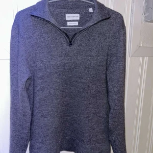 Grå merinoulltröja från These Glory Days - Säljer en stilren grå tröja från These Glory Days i superior merinoull. Tröjan har en praktisk dragkedja vid halsen och långa ärmar. 