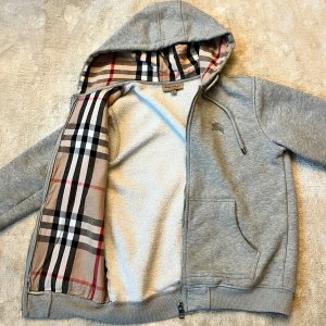 Burberry hoodie - Säljer min gråa Burberry hoodie då jag bytit stil och denna inte kommer till användning. Riktigt härlig hoodie med sjukt skönt material! Cond: 9/10 || Skulle säga att den är nyskick men den har ju använts. Stl: M men passar bättre på S