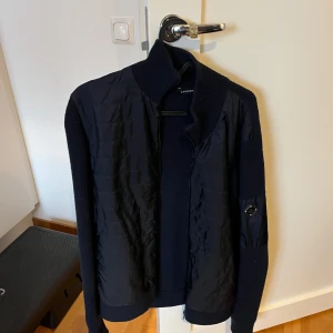 Mörkblå Cardigan från J.Lindeberg - Perfekt till våren, storlek M. Nypris 4000kr, väldigt bra skick inga deffekter.