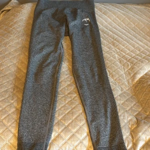 Grå leggings från Peach - Gråa leggings från Peach med hög midja och en tight passform. Perfekta för träning eller en avslappnad dag. Materialet är mjukt och stretchigt för bästa komfort.