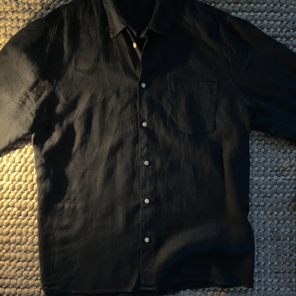 Snygg svart skjorta från Dobber med klassisk krage och knappar framtill. Perfekt för en stilren look. Skjortan har en bröstficka och perfekt passform. Ett utmärkt val inför vår och sommaren! . Paidat.