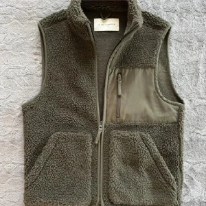 Grön fleeceväst från A Day's March - Säljer en grön fleeceväst från A Day's March. Västen har en dragkedja framtill och praktiska fickor, inklusive en bröstficka med dragkedja. Perfekt för lager-på-lager under kyliga dagar.