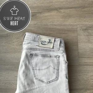 Grå jeans från Jacob Cohen - Snygga grå jeans från Jacob Cohen med klassisk femficksdesign. De har en stilren look och är perfekta för en avslappnad stil. Märkeslappen på baksidan ger en exklusiv touch.