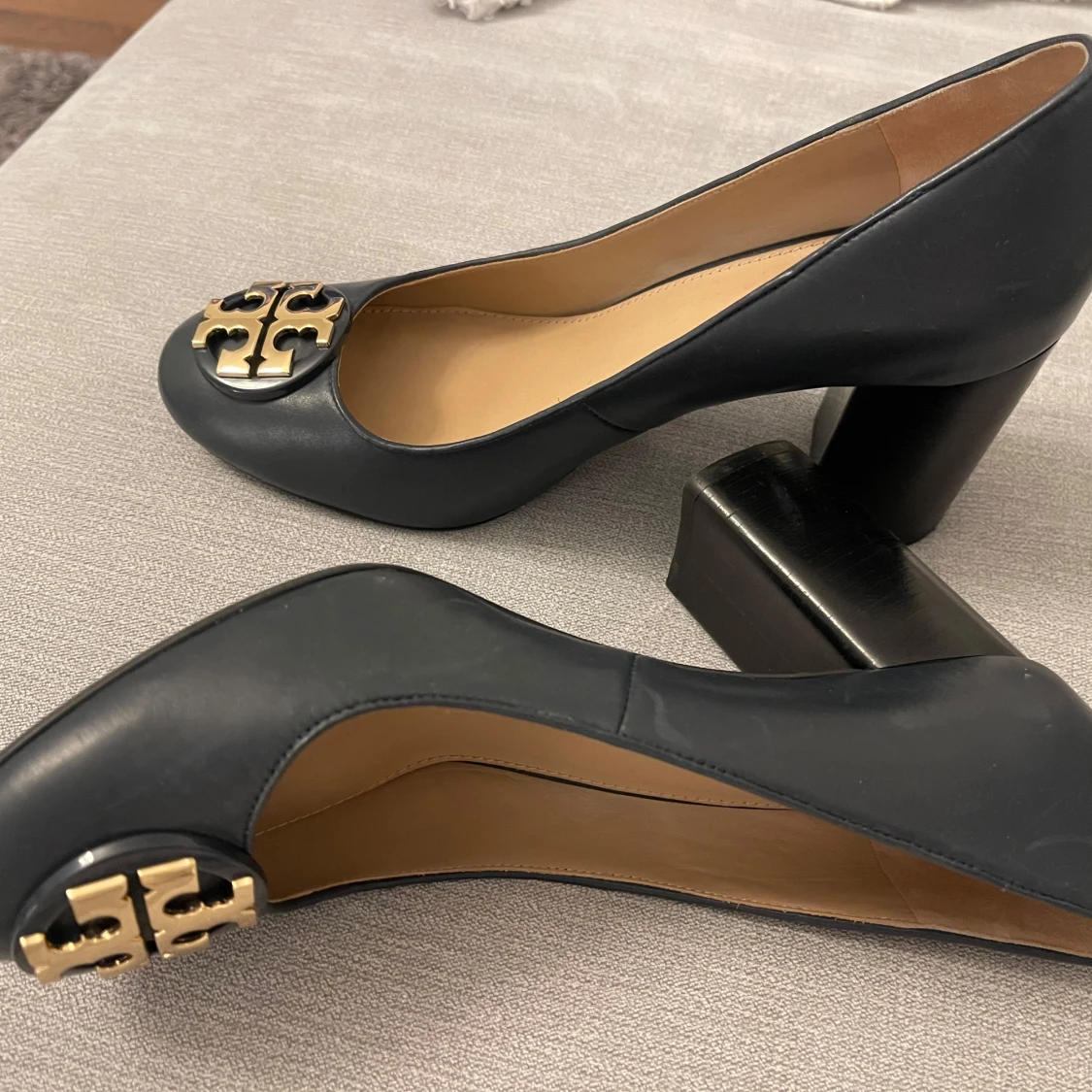 Svarta Tory Burch skor med gulddetalj