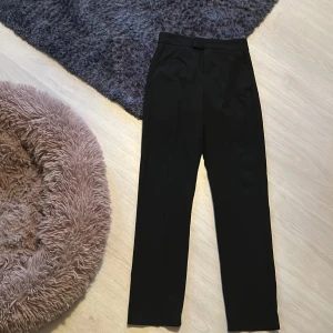 Svarta kostymbyxor från Gina tricot  - Eleganta svarta kostymbyxor med dragkedja och knappstängning. De har en klassisk rak passform och en diskret bakficka. Perfekta för en stilren look. Storlek xxs men passar dom som har xs och s med. Priset är inte satt öppen för alla förslag på priser.