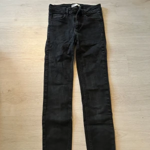 Svarta jeans från Gina Tricot - Snygga svarta jeans från Gina Tricot med en klassisk femficksdesign. De har en smal passform och är perfekta för en stilren look. Jeansen har en knapp och dragkedja framtill. Priset är inte satt öppen för alla förslag på priser.