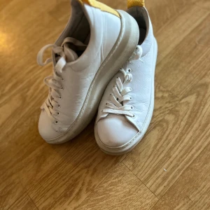 Vita sneakers från Superga  - Säljer ett par klassiska vita sneakers från Superga. Skorna har en enkel och stilren design med snörning och en bekväm sula. Perfekta för en avslappnad stil.