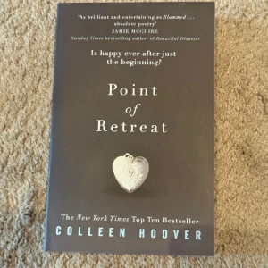 Point of Retreat (oanvänd) - Säljer boken 'Point of Retreat' av Colleen Hoover. Omslaget är mörkgrått med ett silverhjärta i mitten. Boken är på engelska och är en New York Times Top Ten Bestseller. Perfekt för dig som gillar romantik och gripande berättelser.