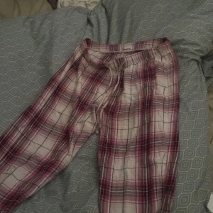 Rosa och vita rutiga mjukisbyxor - Mysiga mjukisbyxor i rosa och vitt rutigt mönster med dragsko i midjan. Perfekta för chill hemma eller när du vill vara extra bekväm. Lätta och luftiga med avslappnad passform.