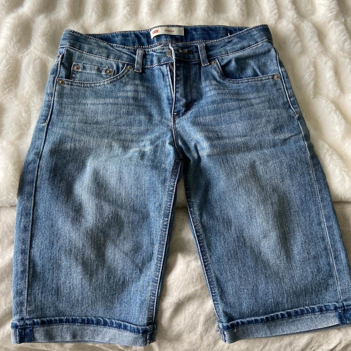 Blå jeansshorts från Levi's. Det passar bra för flickor runt 150m.