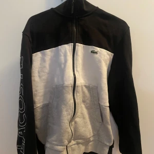 Lacoste zip crewnneck - Riktigt skön Lacoste zipper som är perfekt för lite casual stil och finare tillfällen.                                Cond 8/10, knappt använd och inga flaws.                  Fina detaljer vid vänstra ärmen med fet textad Lacoste.                                                                        Size: M