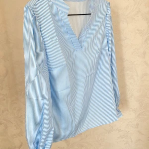 Blåvit randig blus med v-ringning - Snygg blus i blått och vitt. Oanvänd!