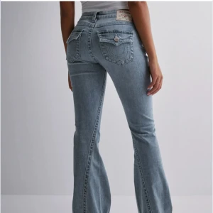 Ljusblå bootcut jeans från True Religion - Säljer ett par ljusblå jeans från True Religion med bootcut-passform. Jeansen har klassiska fem fickor, dekorativa sömmar och logga på bakfickan. Något använda, men nästan som nya. Jag säljer dem eftersom de är för stora för mig. Storlek 25